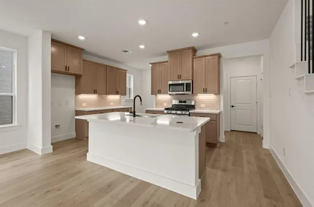 a kitchen with granite countertop white cabinets and stainless steel appliances