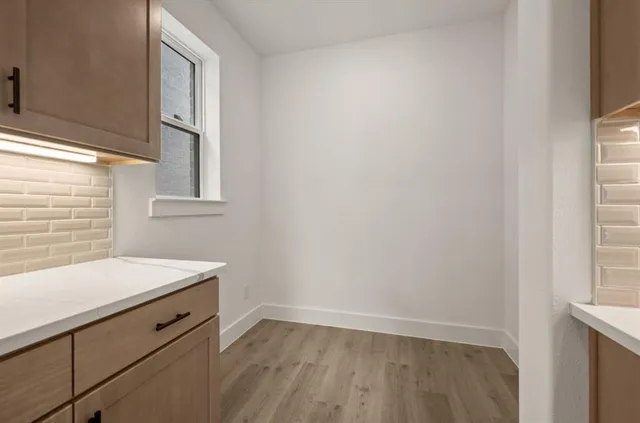 a kitchen with a sink white cabinets and stainless steel appliances