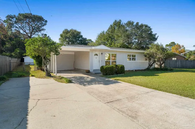 a view of a house with a yard and potted plants