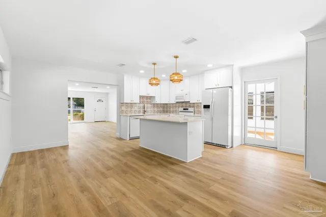 a kitchen with granite countertop white cabinets and white appliances