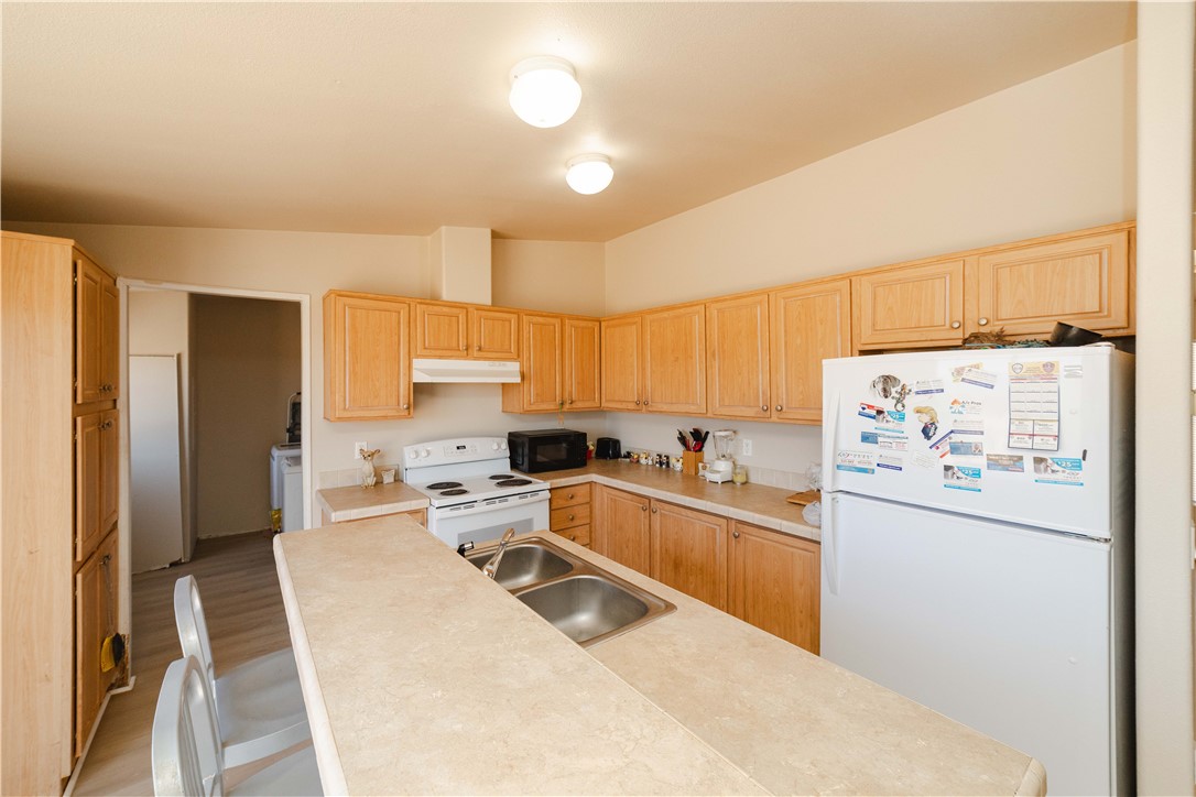 4729 Stewart Mountain Road Golden Valley, AZ 86413 - Photo 7 of 28 a kitchen with granite countertop a refrigerator a sink a stove and cabinets