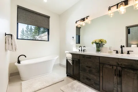 a bathroom with a bathtub sink and mirror