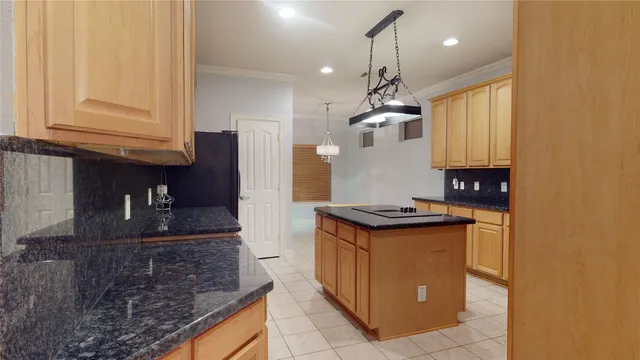 a kitchen with granite countertop a sink a stove and a wooden cabinets