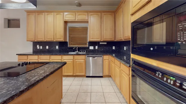 a kitchen with granite countertop a sink a stove and cabinets