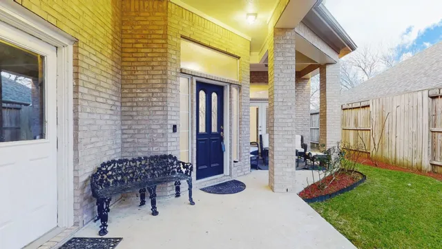 a backyard of a house with sofas table and chairs