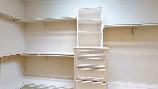 a view of walk in closet with empty racks