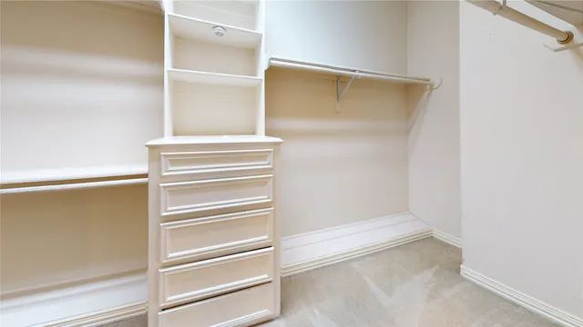 a view of walk in closet with empty racks