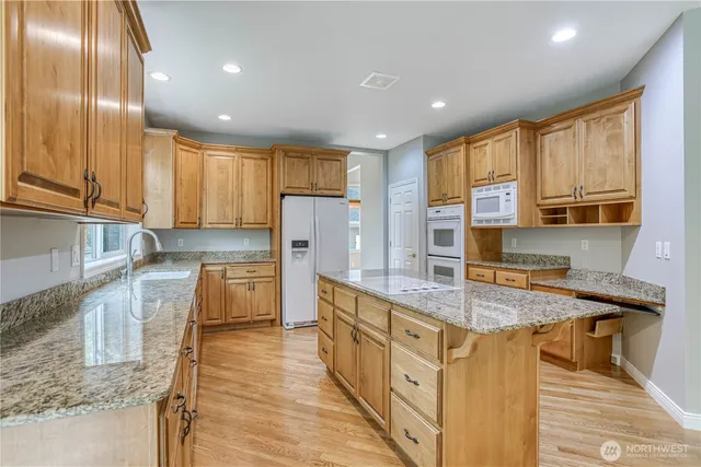 a kitchen with stainless steel appliances granite countertop a sink a stove and a refrigerator