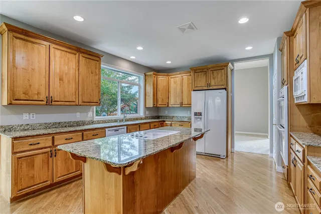 a kitchen with stainless steel appliances granite countertop refrigerator sink and cabinets