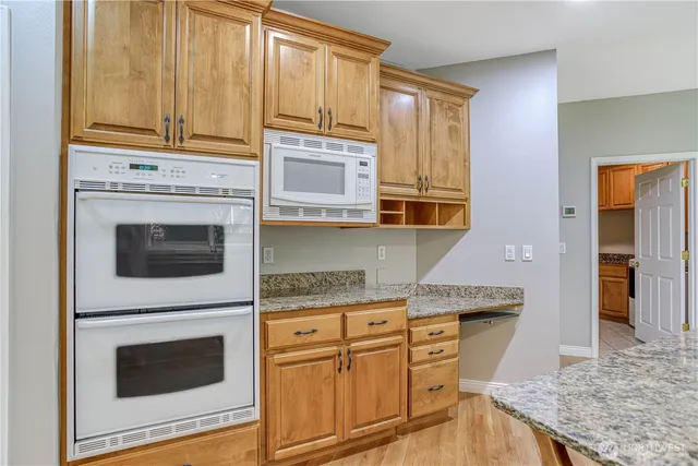a kitchen with stainless steel appliances granite countertop a stove a sink and a microwave