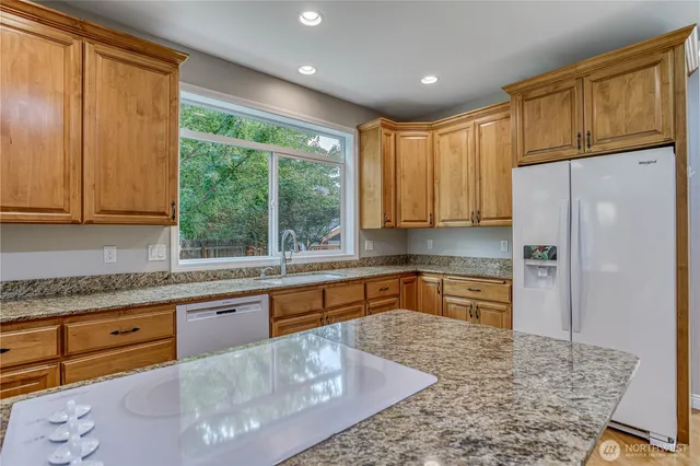 a kitchen with stainless steel appliances granite countertop a refrigerator sink and cabinets