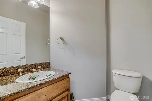 a bathroom with a granite countertop toilet and sink