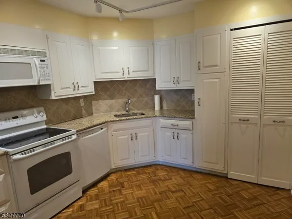 a kitchen with granite countertop white cabinets stainless steel appliances and sink