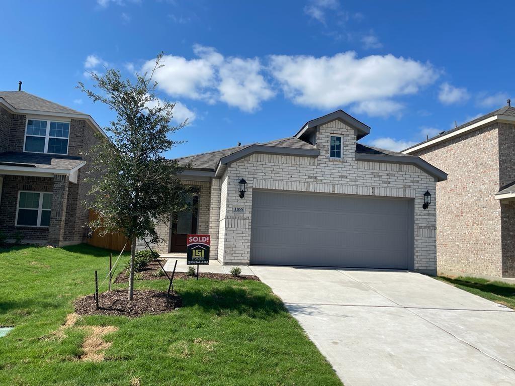 View of front of home with a garage, a front yard, driveway, and brick siding