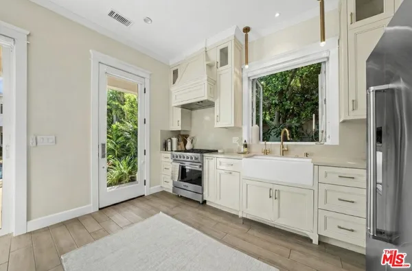 a kitchen with white cabinets and a window