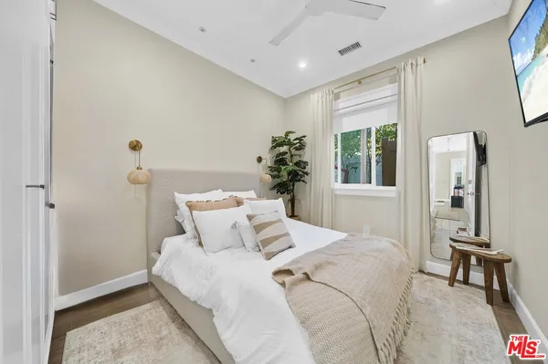 a bedroom with a large bed and a potted plant
