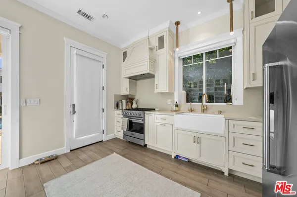a kitchen with white cabinets and sink