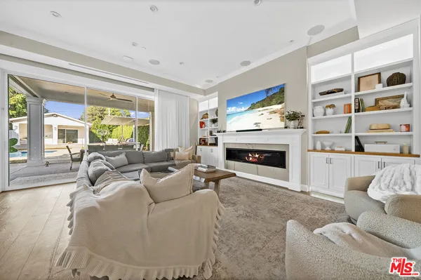 a living room with furniture large window and a fireplace
