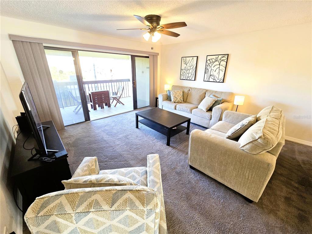 401 150th Avenue, Unit 223 Madeira Beach, FL 33708 - Photo 11 of 50 a living room with furniture and a flat screen tv