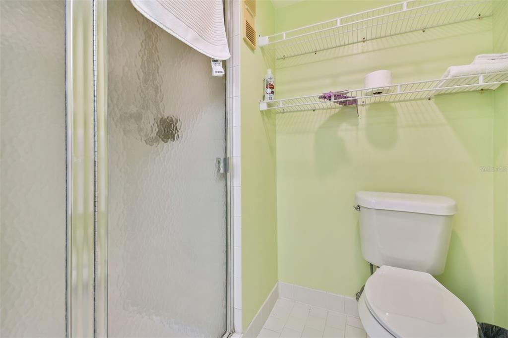 401 150th Avenue, Unit 223 Madeira Beach, FL 33708 - Photo 21 of 50 a white toilet sitting next to a shower curtain