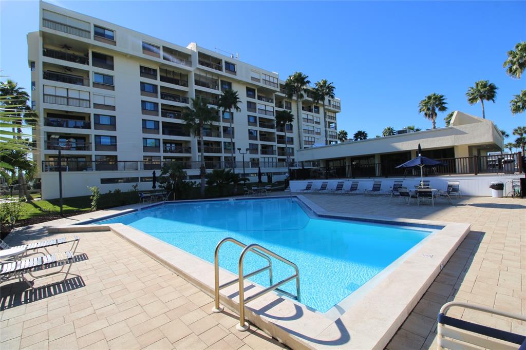 401 150th Avenue, Unit 223 Madeira Beach, FL 33708 - Photo 25 of 50 a view of a swimming pool with outdoor seating and plants