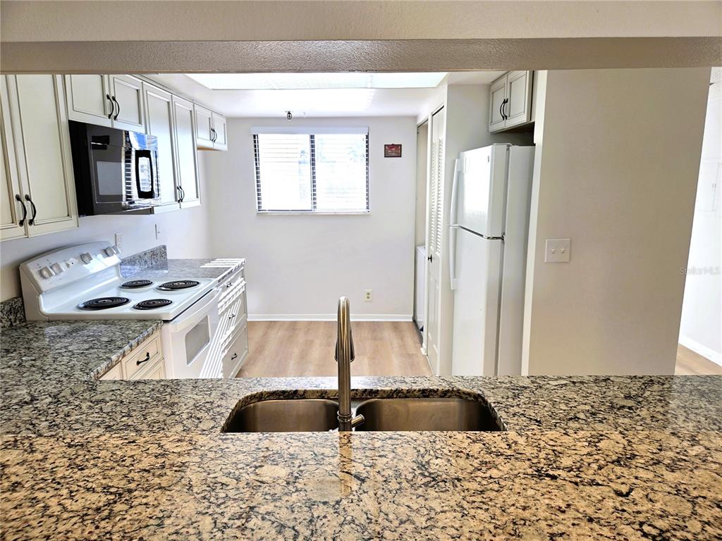 401 150th Avenue, Unit 223 Madeira Beach, FL 33708 - Photo 8 of 50 a kitchen with a sink stove and refrigerator