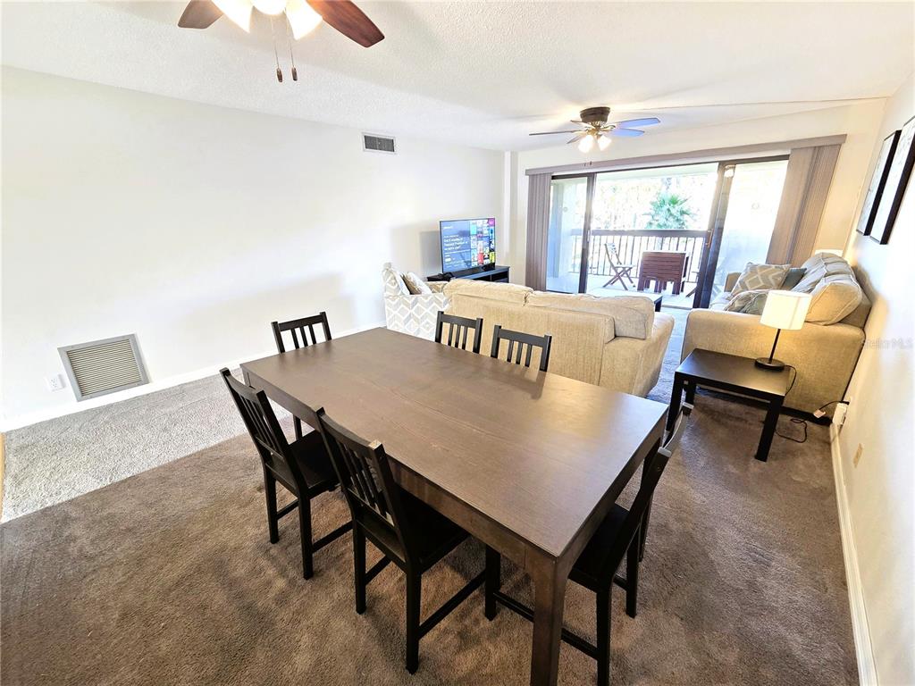 401 150th Avenue, Unit 223 Madeira Beach, FL 33708 - Photo 9 of 50 a view of a dining room with furniture and wooden floor