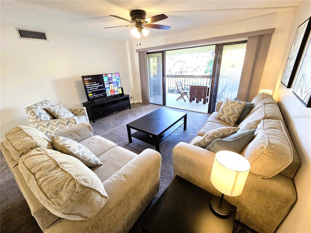 401 150th Avenue, Unit 223 Madeira Beach, FL 33708 - Photo 10 of 50 a living room with furniture and a flat screen tv
