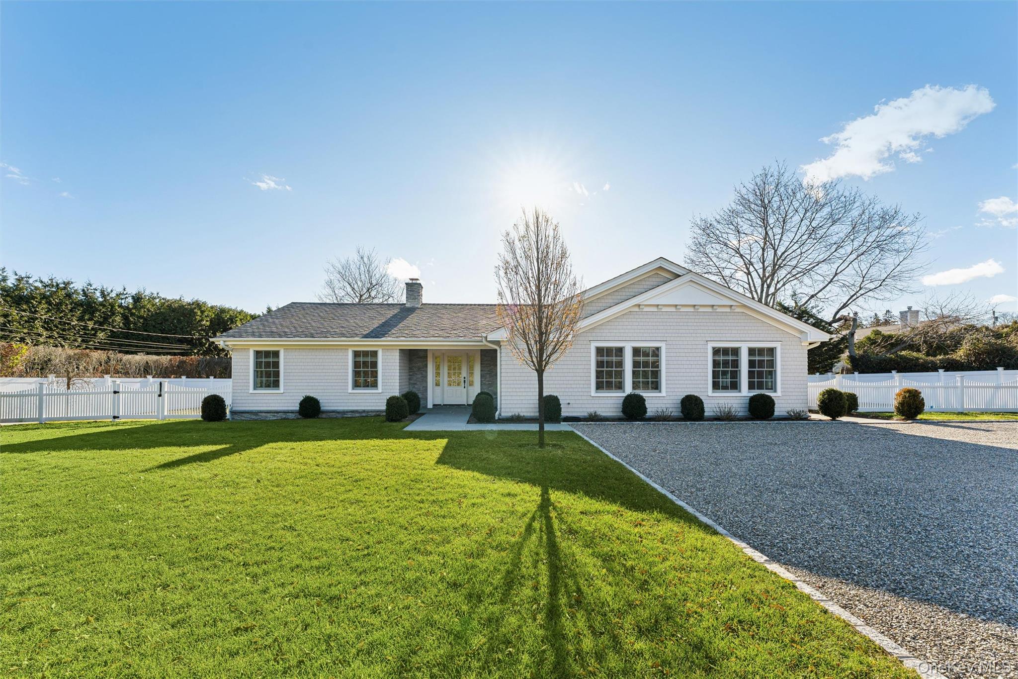 a view of a house with a big yard and large trees