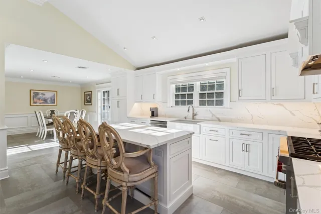a kitchen with stainless steel appliances granite countertop a stove a sink a oven a dining table and chairs