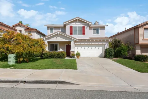 a front view of a house with a yard and a garage