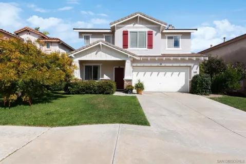 a front view of a house with a garden and plants