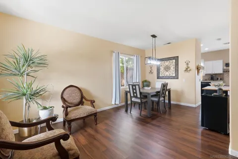 a dining room with furniture a chandelier and wooden floor