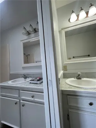a bathroom with a granite countertop sink and a mirror