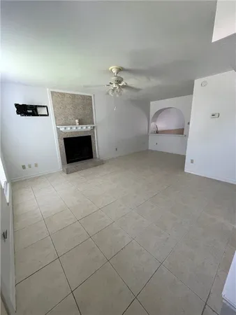 an empty room with a ceiling fan and white walls