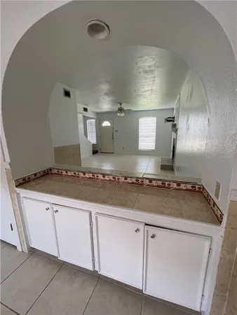 a kitchen with granite countertop a sink and white cabinets