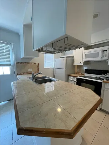 a kitchen with kitchen island sink stove and cabinets