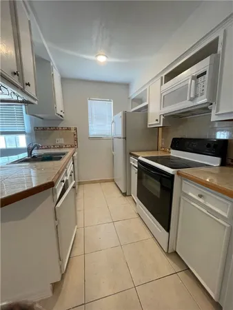 a kitchen with a stove a sink and a microwave