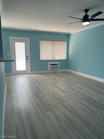 a view of an empty room with wooden floor