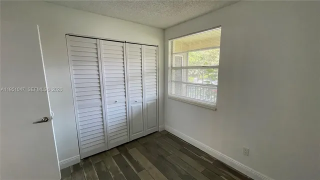 a view of a small space with wooden floor and a window