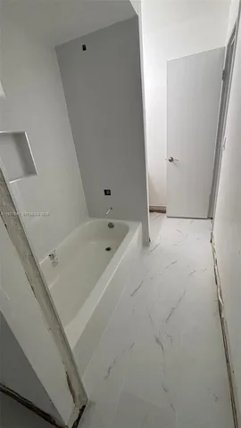 a white bath tub sitting next to a white sink