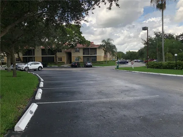 a view of a house with a big yard and large trees