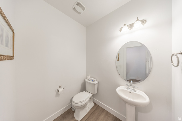 4765 Breezy Patch Road Eagle Mountain, UT 84005 - Photo 11 of 25 Powder room featuring a pedestal sink, oval mirror, and wood-finish flooring
