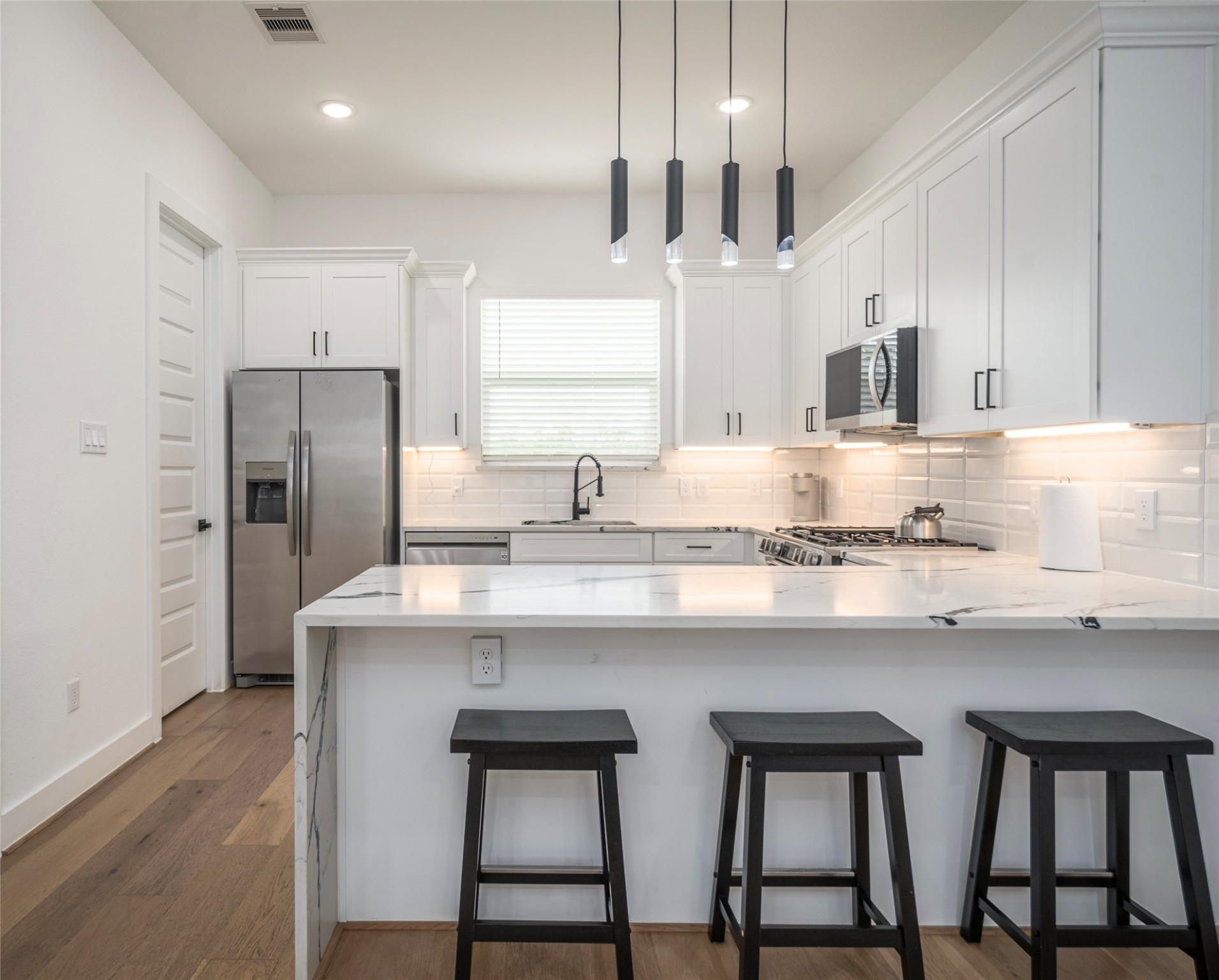 316 Thornton Road, Unit D Houston, TX 77018 - Photo 7 of 8 a kitchen with stainless steel appliances granite countertop a sink a stove a refrigerator and island with wooden floor