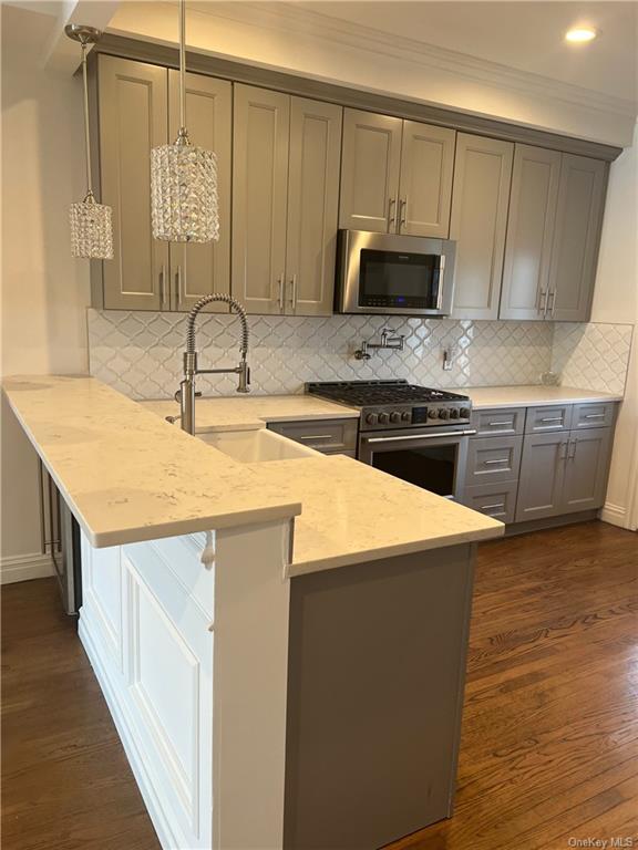 240-250 Pelham Road New Rochelle, NY 10805 - Photo 6 of 36 Welcome to the large, upscale and luxurious kitchen in Unit 248 Only. It's just perfect for the culinary aficionados! This room features lots of sumptuous wooden cabinets, stainless steel appliances and quartz counter tops!