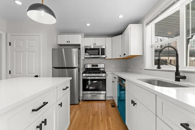 a kitchen with granite countertop a refrigerator stove and sink