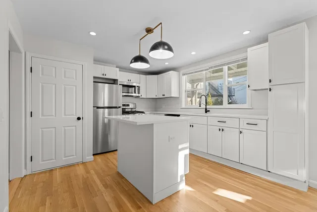 a kitchen with cabinets and wooden floor