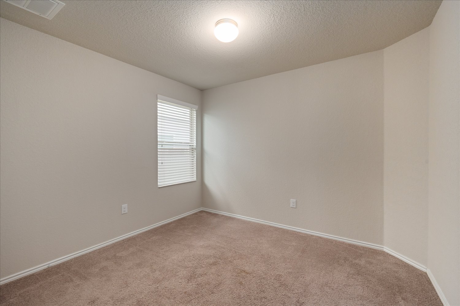 5812 Bell Tower Lane Austin, TX 78747 - Photo 19 of 24 Empty room with a textured ceiling and carpet floors