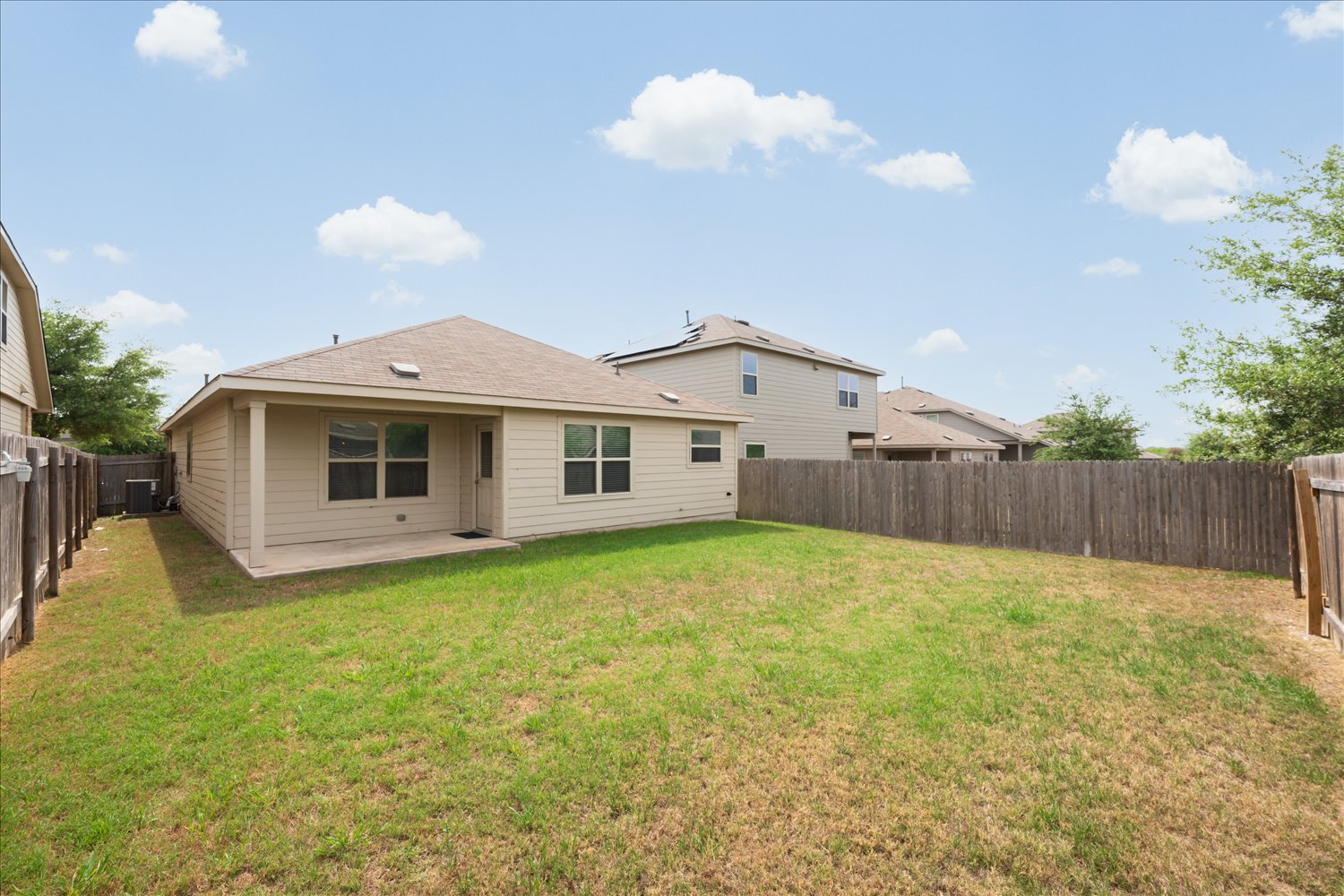 5812 Bell Tower Lane Austin, TX 78747 - Photo 23 of 24 Back of house with a fenced backyard, a patio area, and a shingled roof