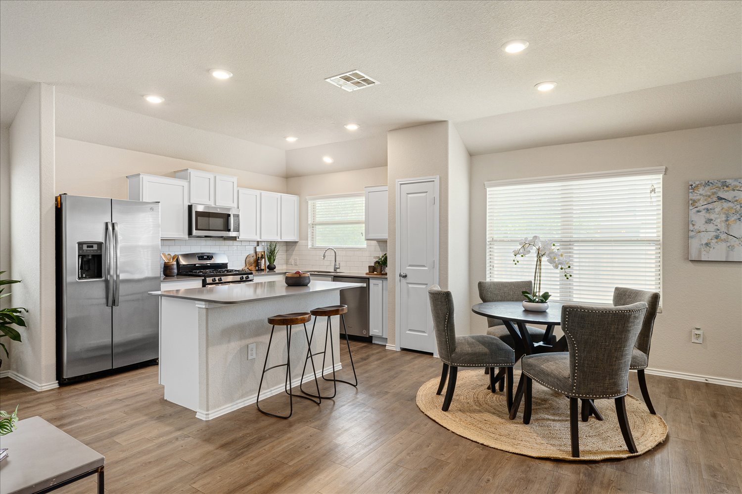 5812 Bell Tower Lane Austin, TX 78747 - Photo 7 of 24 Kitchen with white cabinetry, stainless steel appliances, a kitchen island, a breakfast bar, and light countertops